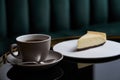 Cup of tea and slice of cheesecake on white plate on table Royalty Free Stock Photo