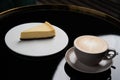 Cup of tea and slice of cheesecake on white plate on table Royalty Free Stock Photo