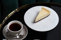 Cup of tea and slice of cheesecake on white plate on table Royalty Free Stock Photo
