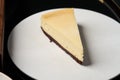 Cup of tea and slice of cheesecake on white plate on table Royalty Free Stock Photo