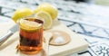 Cup of tea with a slice of lemon on a cutting board with lemons, a knife, and sugar Royalty Free Stock Photo