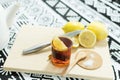 Cup of tea with a slice of lemon on a cutting board with lemons, a knife and sugar Royalty Free Stock Photo