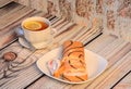 A cup of tea with a slice of lemon and a plate and biscuit roll with cream on a wooden table Royalty Free Stock Photo