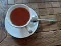 A cup of tea with a spoon on the table in a cafe