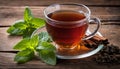 A cup of tea with a sprig of mint and cinnamon sticks on a wooden table