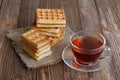 Cup of tea and stack of waffles and cookies