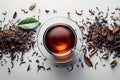 Cup of tea is surrounded by tea leaves and a leaf Royalty Free Stock Photo