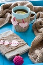 A cup of tea in sweater, old notebook with hearts of felt, beige