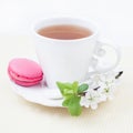 Cup of tea and sweet and colourful strawberry french macaroon an