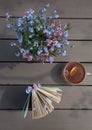 Cup of tea on the table, a book and a bouquet of forget-me-nots