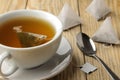 Cup with tea and tea bag pyramid. close-up. on a wooden table. to make tea Royalty Free Stock Photo