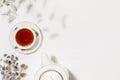 Cup of tea, teapot and dry flowers on white background with copy space