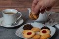 Cup of tea with a teapot and a male hand picking up a cookie Royalty Free Stock Photo