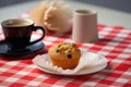 cup of tea, warm scone, and delicious muffin on checkered tablecloth