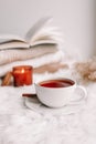 A cup of tea on the window with burning candles and sweaters Royalty Free Stock Photo