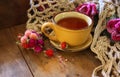 Cup of tea wit old book h autumn leaves and a warm scarf on wooden table