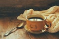 Cup of tea wit old book h autumn leaves and a warm sweater on wooden table