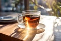 Cup of tea on the wooden table in cafe. warm morning dawn sun light