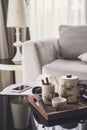 Cup of tea on wooden tray on a round table with sofa in living r Royalty Free Stock Photo