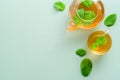 Cup and teapot with mint tea and leaves on green background. Herbal tea concept. Flat lay, top view, copy space Royalty Free Stock Photo