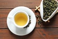 Cup of Tie Guan Yin oolong and chahe with tea leaves on wooden table