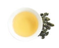 Cup of Tie Guan Yin oolong and tea leaves on white background Royalty Free Stock Photo