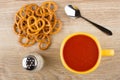 Cup of tomato juice, heap of pretzels, salt and spoon Royalty Free Stock Photo