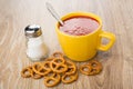 Cup of tomato juice with spoon, heap of pretzels Royalty Free Stock Photo