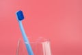 Cup with toothbrush on table against color background Royalty Free Stock Photo