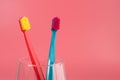 Cup with toothbrushes on table against color background. Royalty Free Stock Photo