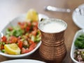 A cup of turkish ayran and turkish dinner on wood table