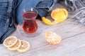 A cup of Turkish black tea and orange and lemon slices next to the clothing Royalty Free Stock Photo