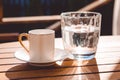 A cup of Turkish coffee and a glass of water on the wooden table on a terrace in a garden, coffee break