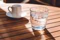 A cup of Turkish coffee and a glass of water on the wooden table on a terrace in a garden, coffee break