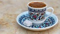 A Cup of Turkish Coffee on a marble table with a traditional ottoman motif cup beside Turkish Delight and enough space for Royalty Free Stock Photo