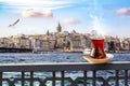 A cup of Turkish tea in a traditional glass against the background of the Golden Horn and the Galata Tower in Istanbul Royalty Free Stock Photo