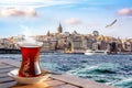 A cup of Turkish tea in a traditional glass against the background of the Golden Horn and the Galata Tower in Istanbul Royalty Free Stock Photo