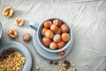 Cup with unpeeled hazelnuts on table