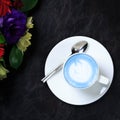 Cup of vegan blue latte on dark drop. Concept of trendy coffeine free vegan refreshment break