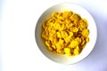 A Cup of yellow cornflakes in milk on a white background Royalty Free Stock Photo