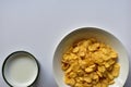 A Cup of yellow cornflakes in milk on a white background Royalty Free Stock Photo