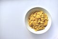 A Cup of yellow cornflakes in milk on a white background Royalty Free Stock Photo