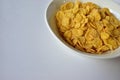 A Cup of yellow cornflakes in milk on a white background Royalty Free Stock Photo