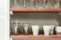 Cupboard with light red shelves filled with china