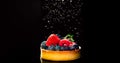 Cupcake with berries sprinkled with icing sugar on black background.Food concept.Close-up Royalty Free Stock Photo