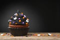 Cupcake. Black cupcake on Halloween. Dessert on Halloween party. Chocolate muffin decorated with colored sprinkles Royalty Free Stock Photo