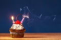 Cupcake with blown out burning candles on top