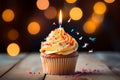 Cupcake with candle, birthday delight, bokeh lights backdrop, festive