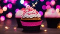 cupcake with candle A pink cupcake with a sparkler and fairy lights. The cupcake has white frosting and a red sprinkles Royalty Free Stock Photo