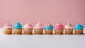 cupcake with candles A row of colorful birthday cupcakes isolated on a pink background. Royalty Free Stock Photo